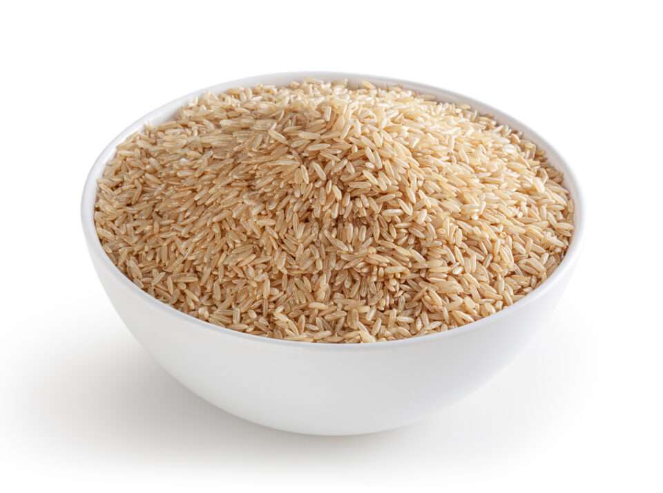 Brown rice in white bowl isolated on white background