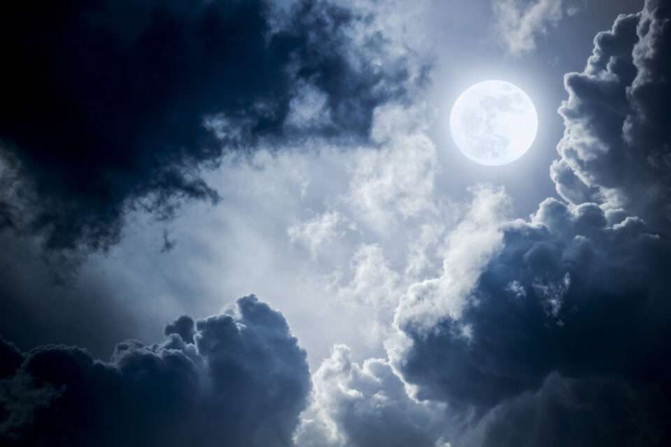 Bright shining moon between clouds